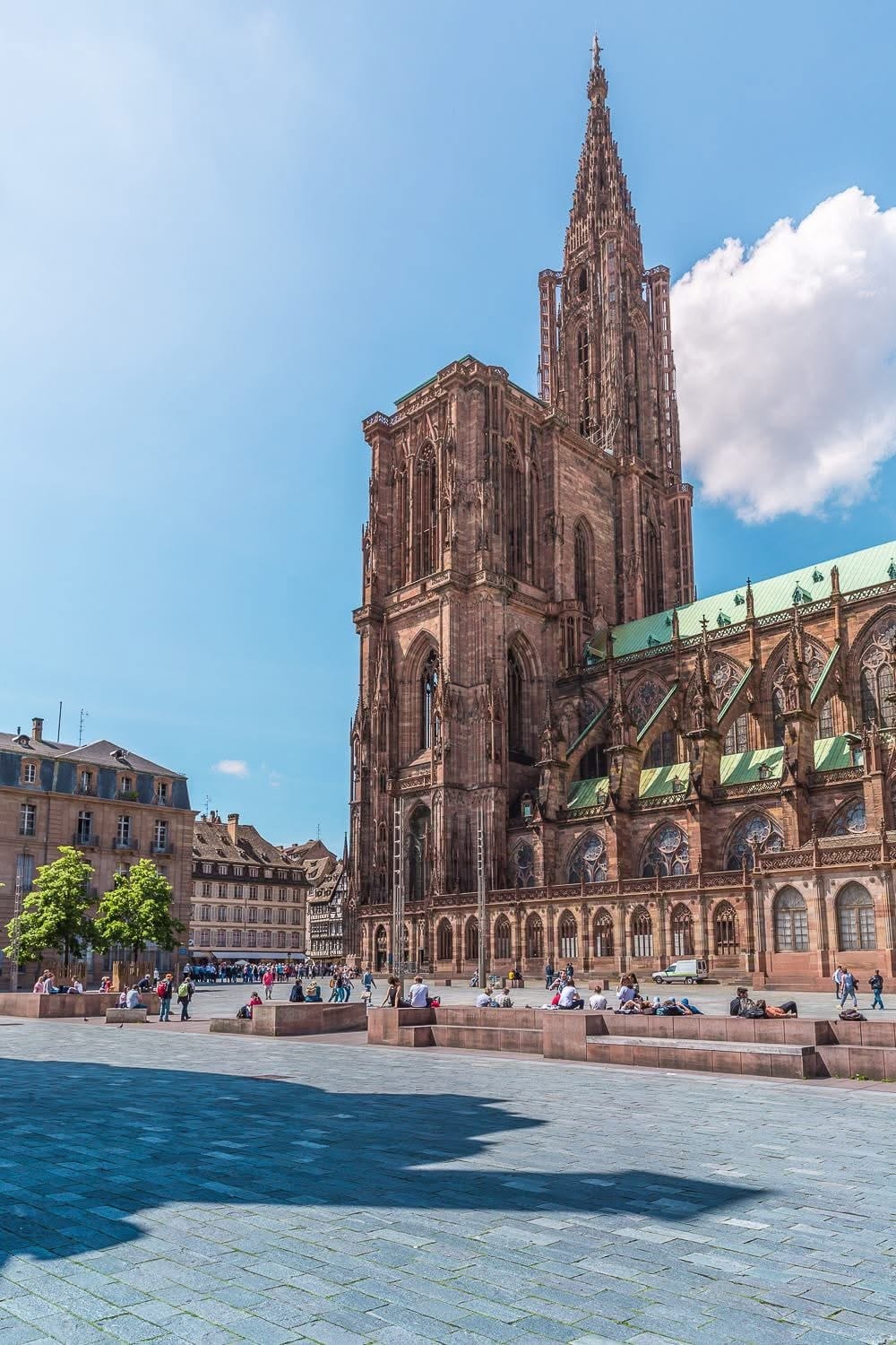 La cathédrale de Strasbourg et sa flèche de grès rose sous un ciel bleu, vue de la place