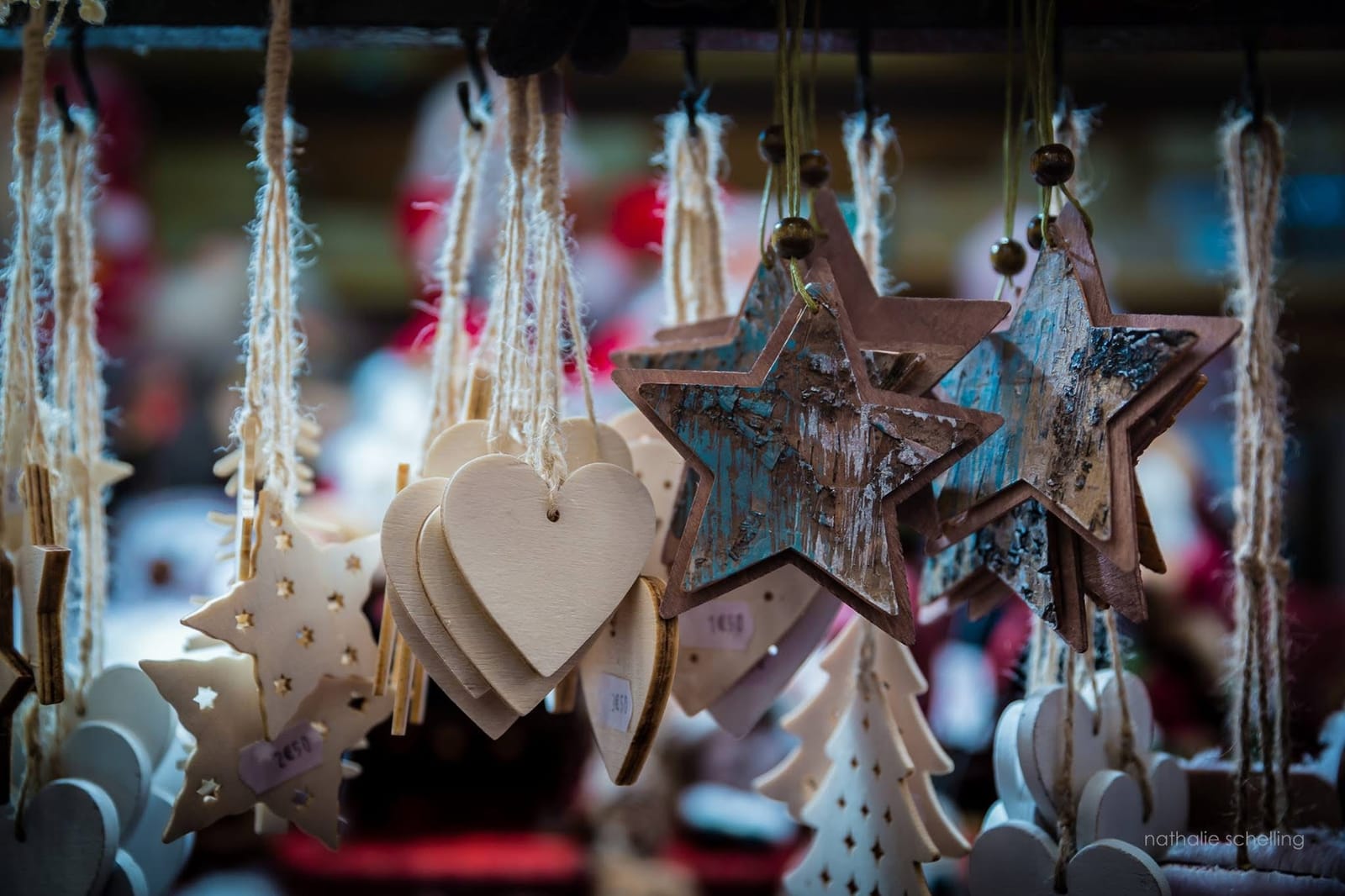 Étoiles et cœurs de bois blanc suspendus à un chalet du marché de Noël