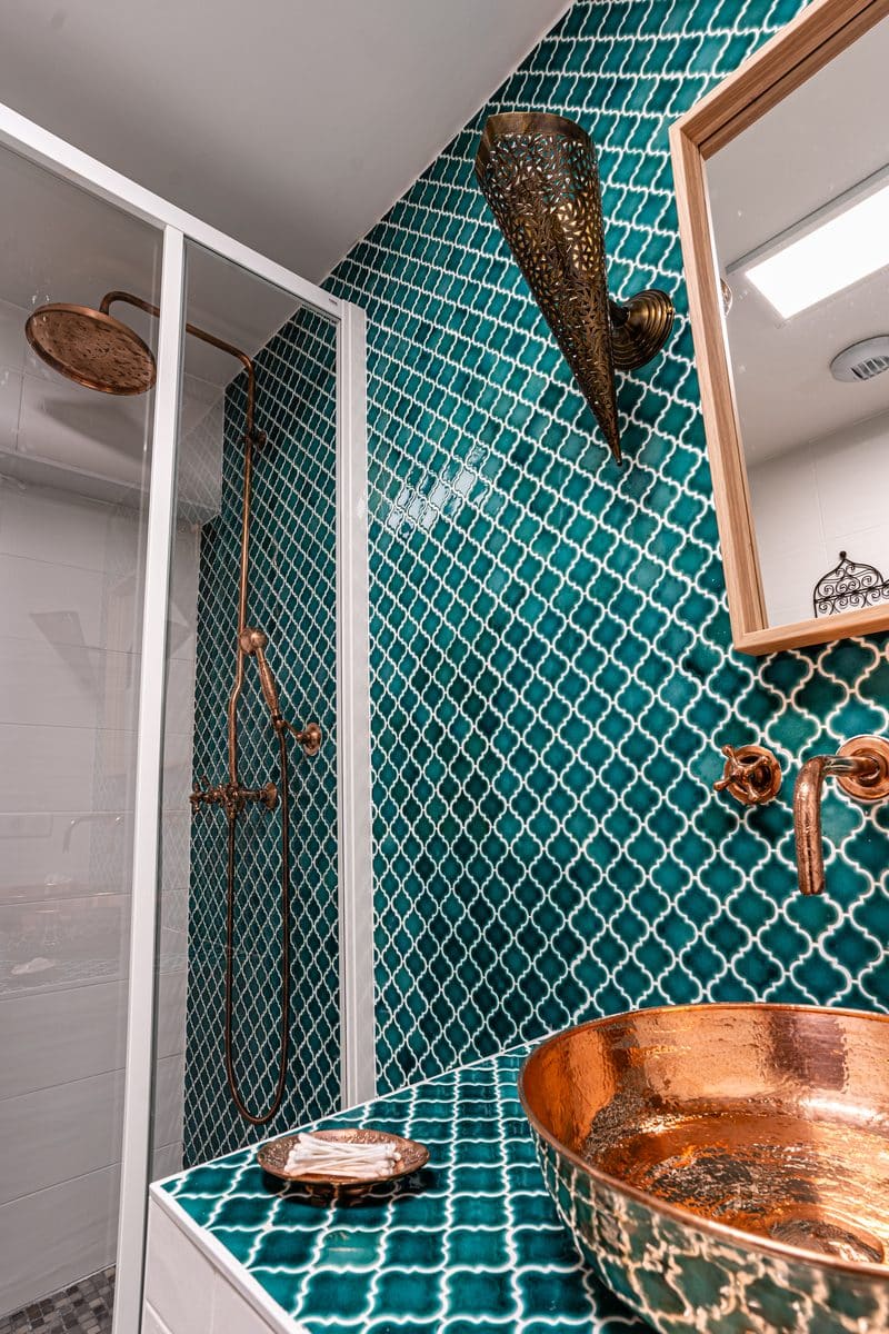 La douche à l'italienne et une vasque de cuivre, sur la faïence émeraude