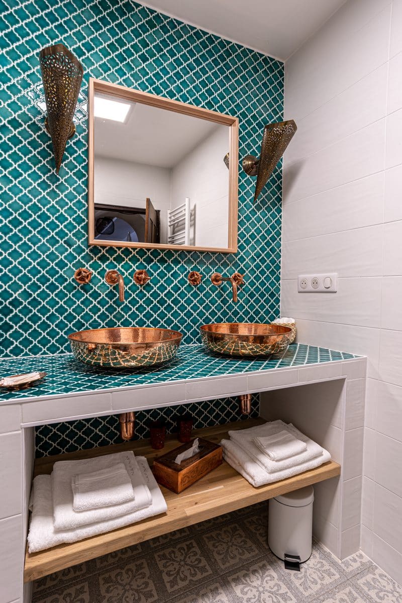 La salle de bain : les deux vasques de cuivre, le miroir et les serviettes pliées