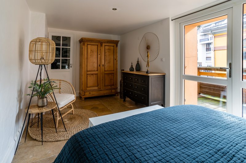 La seconde chambre : lit bleu, armoire ancienne et porte-fenêtre sur la terrasse