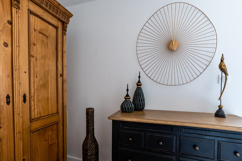 Un détail de la seconde chambre : oiseaux dorés, commode bleu nuit et miroir soleil