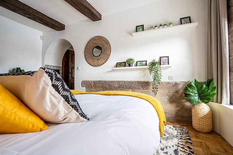 Les coussins jaunes et le mur de pierre de la chambre, près de la fenêtre