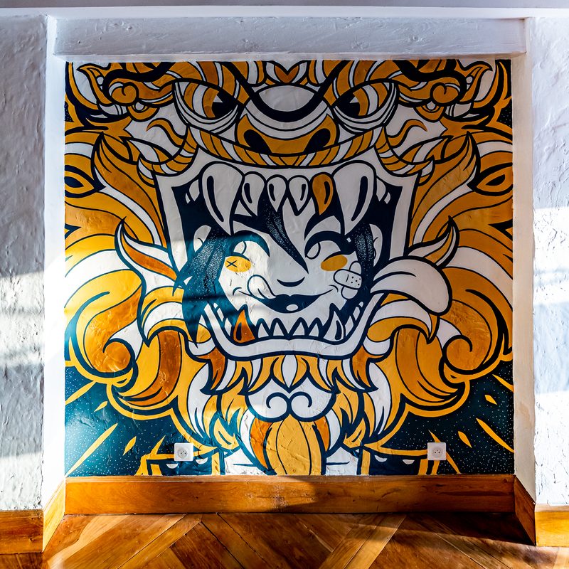 Le panneau central de la fresque de Williann : le visage aux crocs dorés, en bleu, jaune et or