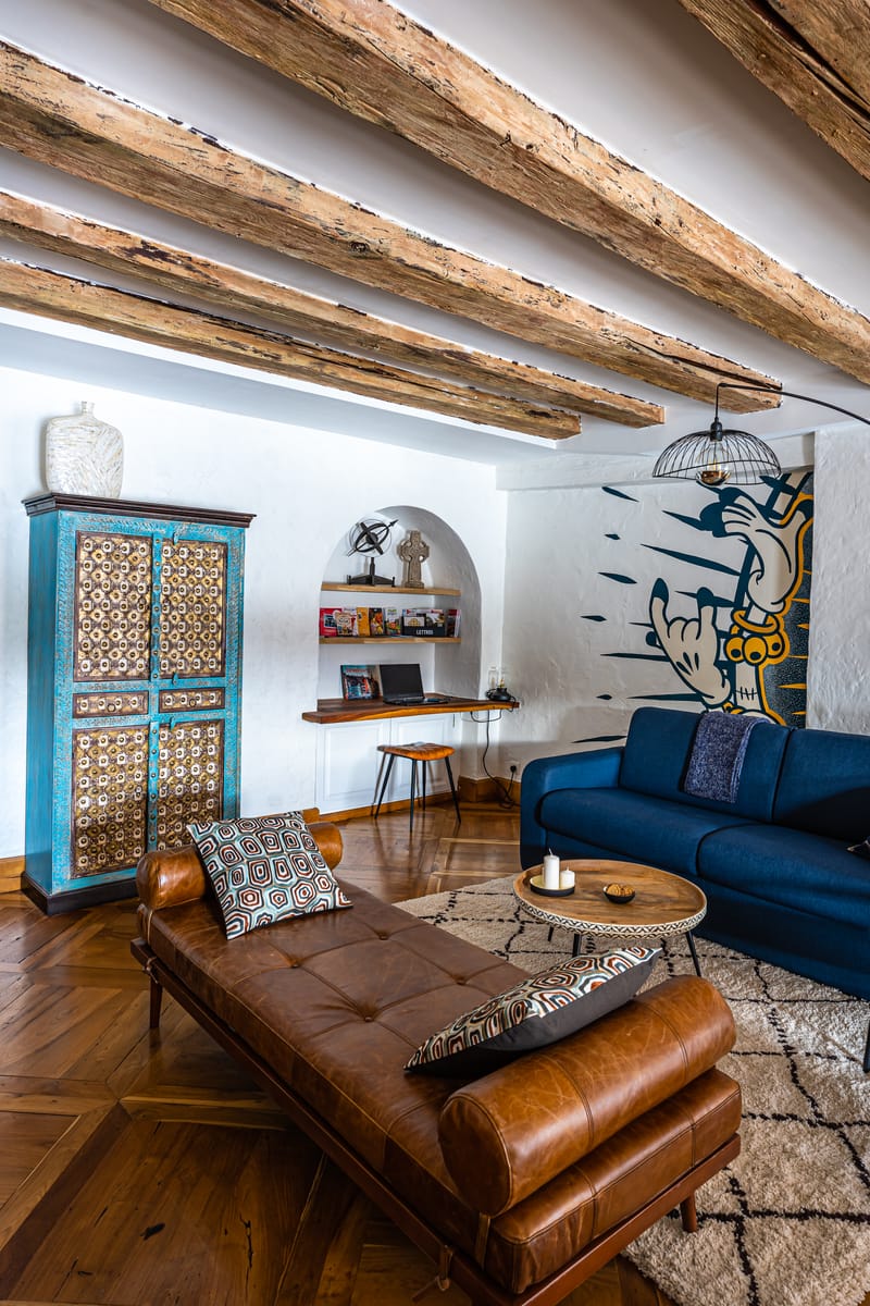 Le meuble marqueté du salon, le canapé bleu et un second pan de la fresque