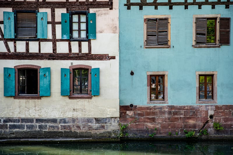 Deux façades voisines de la Petite France, l'une à colombages, l'autre bleu-vert, au ras de l'eau