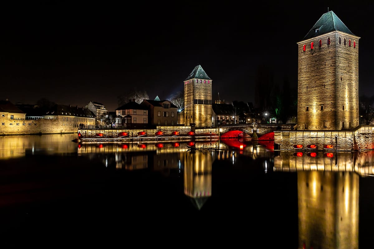 Les tours des Ponts Couverts éclairées au bord de l’Ill à Strasbourg