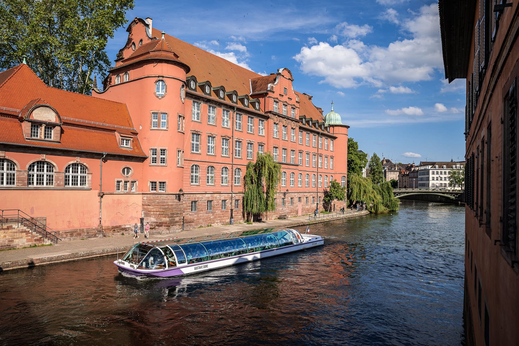 Un bateau-promenade sur l&rsquo;Ill devant les façades de Strasbourg, en contrebas du Moulin aux Épices
